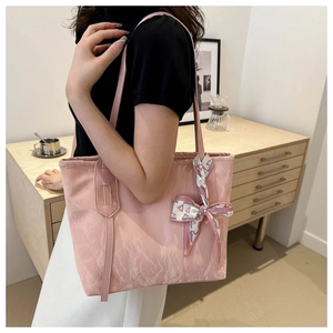 Pink nylon tote bag with fashion scarf detail shown being worn in a cozy indoor setting