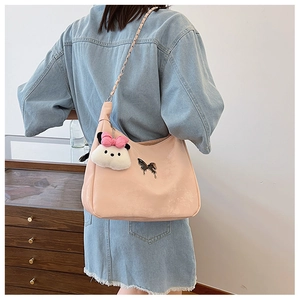 Detail of pink shoulder bag with metal chain strap and cute white plush doll charm
