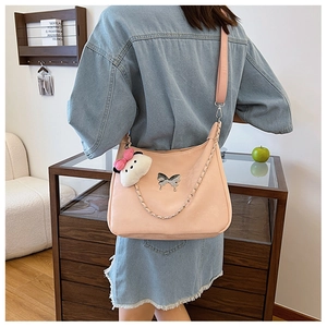 Pink crossbody bag with metal butterfly clasp, chain detail and plush pendant