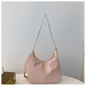 Detail of light pink hobo bag with metal chain strap and adjustable leather shoulder strap
