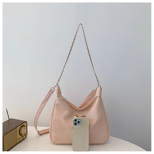 Pink crescent hobo bag with gold chain, bow detail, and phone for size comparison
