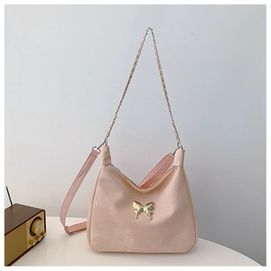 Detail of soft peach crossbody bag with golden butterfly buckle and dual strap options