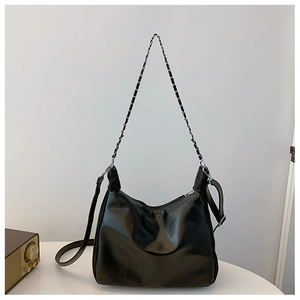 Close-up of black PU leather shoulder bag featuring silver chain and adjustable strap