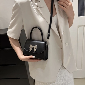 Chic black mini crossbody bag with silver metal bow detail and elegant top handle