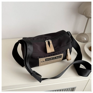 Close-up of waterproof Oxford cloth crossbody bag with sports label and metal zippers