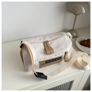 Detail of off-white canvas crossbody sports bag with brown leather logo and dual zippers