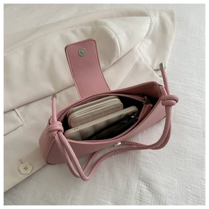 Detail of pink underarm bag interior showing storage for phone, wallet and sunglasses