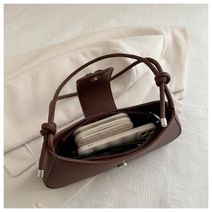 Top view of brown leather bag interior showing space for phone, wallet and accessories