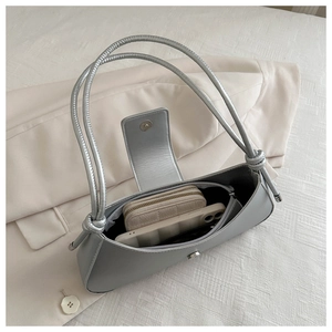 Macro shot showing internal capacity of silver metallic shoulder bag with phone and wallet