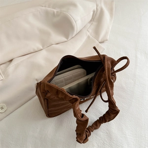Dark brown pleated shoulder bag with interior space showing wallet and phone