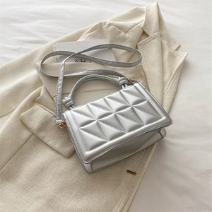 Chic silver rectangular quilted handbag with cylindrical handle and shoulder strap