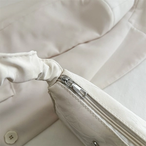 Chic off-white pleated baguette bag with premium silver zipper and soft leather texture