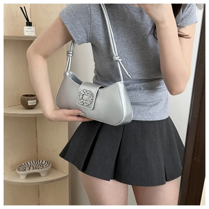 Detail of silver crescent armpit bag with rhinestone square buckle and knotted handle