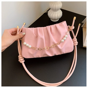 Detail of pink pleated shoulder bag with pearl chain and golden flower charms