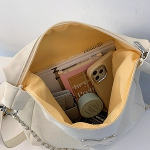 Large beige crossbody bag with yellow lining showing spacious interior for daily essentials