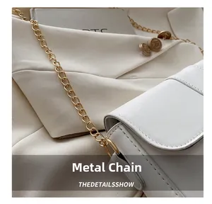 Detailed close-up of golden metal chain link and white leather buckle on shoulder bag