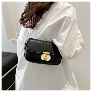Detail of black leather square bag with gold-tone hardware clasp and chain shoulder strap