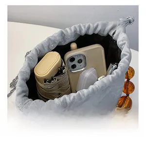 Détail de la capacité intérieure d'un sac seau gris montrant téléphone et parapluie