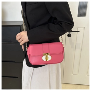 Detail of pink chain square bag featuring a gold T-bar lock and metallic chain strap