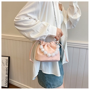 Détail du sac seau rose avec poignée en perles translucides et bandoulière chaîne