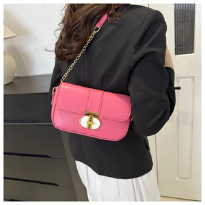 Pink chain crossbody bag worn by model, showing compact size and gold turn-lock detail