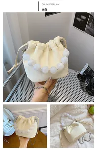 Détail du sac seau blanc cassé avec poignée en perles et chaîne argentée