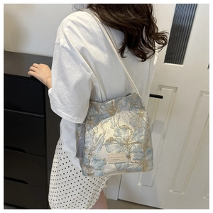 Détail d'un grand sac cabas avec jacquard floral doré et pampille à franges grises