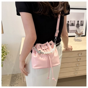 Detailed view of pink drawstring bucket bag with pearl and silver bead handle