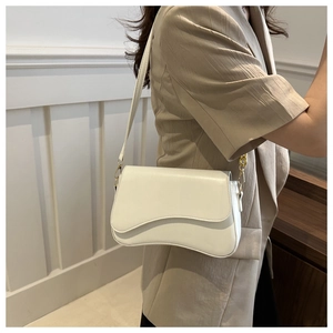 Detail of off-white baguette bag featuring wavy flap edge and gold metal hardware hooks