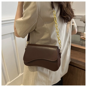 Close-up of a dark brown shoulder bag with wavy base design and gold chunky chain