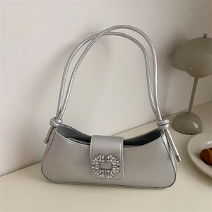 Silver metallic crescent underarm bucket bag with decorative buckle and knotted strap