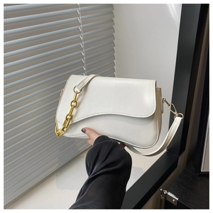 Detail of white matte leather bag with wavy edge flap and thick gold chain strap
