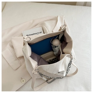 Spacious interior of beige tote bag showing daily essentials like umbrella and notebook