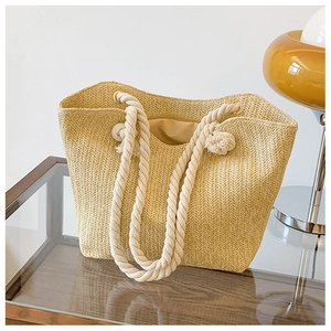 Detail of straw woven tote bag featuring white cotton rope handles and fabric lining