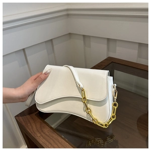 Close-up of white curved flap bag with golden metal chain and thin leather strap
