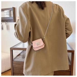 Détail du mini sac bandoulière rose avec boucle papillon argentée et bandoulière chaîne