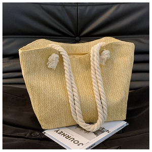 Macro shot of natural straw tote bag texture and white cotton rope handles