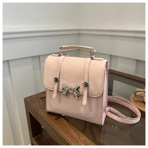 Détail du mini sac à dos rose avec nœud argenté et bretelles réglables