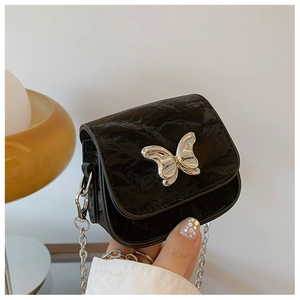 Détail du mini sac bandoulière noir avec boucle papillon argentée et chaîne