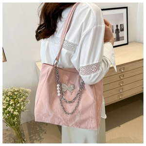 Pink pleated tote bag detail featuring silver butterfly charm and pearl chain straps