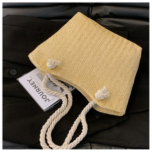 Detail of woven straw tote bag with chunky cotton rope handles and herringbone pattern