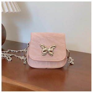 Détail du mini sac à chaîne rose avec texture froissée et boucle papillon argentée