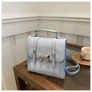 Détail du mini sac à main bleu clair avec nœud en métal argenté et design rétro