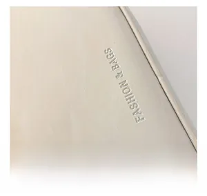 Close-up of cream faux leather handbag with silver embossed Fashion & Bags lettering