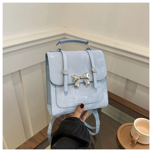 Detail of light blue mini backpack with silver butterfly accent and top handle strap
