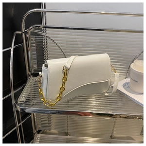 White minimalist leather handbag with unique curved bottom and decorative gold chain