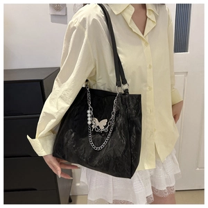 Large black textured tote bag with silver butterfly chain and pearl detail for women