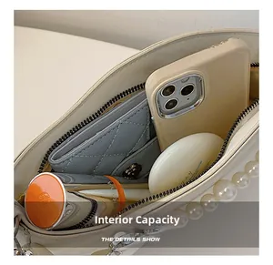 Internal capacity of off-white pearl handbag showing phone, wallet and cosmetics