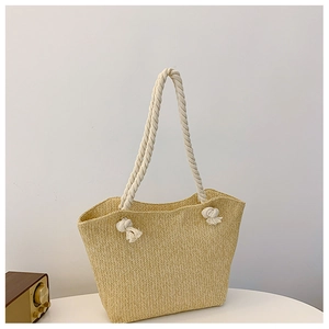 Detailed V-shaped weave pattern on beige straw tote bag with thick white rope handles