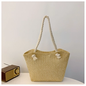 Close-up of woven straw texture and thick cotton rope handle with knotted decorative details